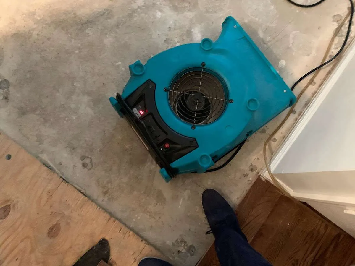 Air mover drying subfloor during Commercial Water Damage Restoration in Pawtucket